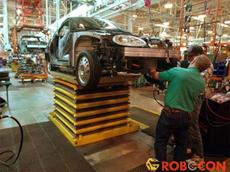 Công nhân tại một nhà máy General Motors lắp động cơ vào điện vào chiếc xe mới trong năm 1996.