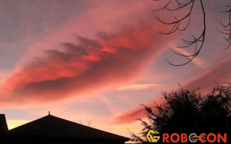 Đám mây dưới nắng chiều như một đôi môi đỏ mọng đang hôn lên mái nhà.