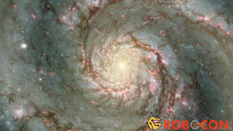 Bức ảnh thiên hà Xoáy Nước (Whirlpool) cho thấy các ngôi sao đang ra đời (các chấm màu đỏ). Bụi ở chính giữa thiên hà được cho là đang bị hút vào trong lỗ đen khổng lồ của thiên hà này.