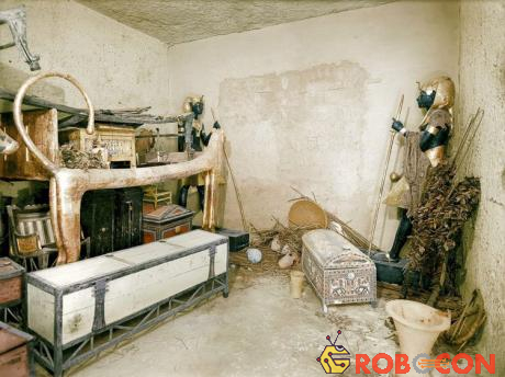 Một chiếc giường sư tử mạ vàng, rương quần áo và những vật dụng khác trong phòng. Tường của phòng chôn cất được bảo vệ bởi những bức tượng.