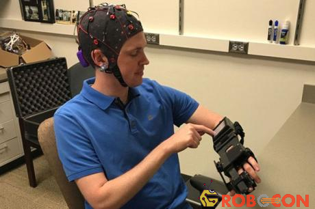 Bác sĩ Jarod Roland thử thiết bị làm cho bàn tay của mình mở và đóng theo đáp ứng các tín hiệu não