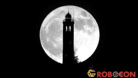 Siêu trăng mọc từ sau ngọn hải đăng ở San Maurizio, Italy. 