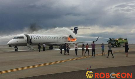 Những hành khách đã thoát ra lại lẩn quẩn kế bên chiếc máy bay đang cháy để chụp ảnh.