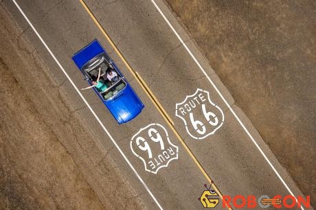 Cặp đôi ngồi trên chiếc Ford Mustang Convertible di chuyển dọc đường Route 66 ở Mỹ.