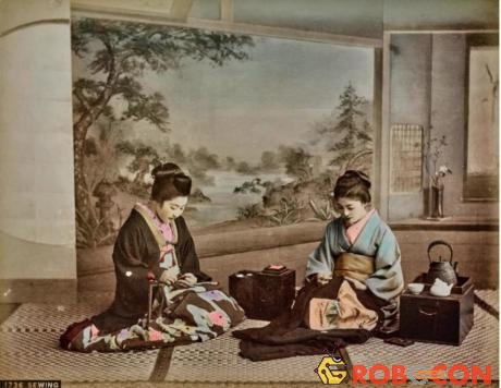 Một bức ảnh cho thấy hai người phụ nữ đang may vá trong khung cảnh truyền thống. 
