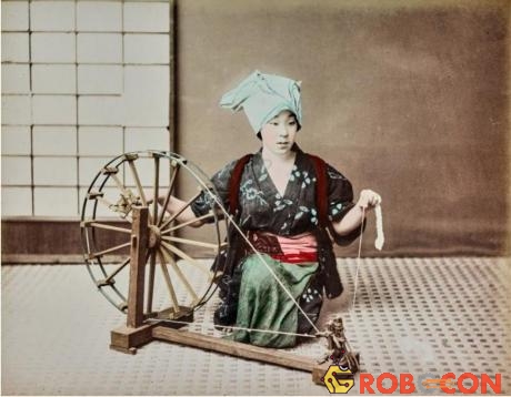 Một phụ nữ đang ngồi dệt vải.