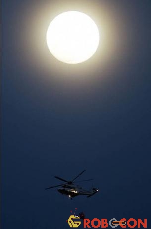 Trực thăng chở nước của chính phủ Paksistan bay dưới trăng xanh ở Islamabad