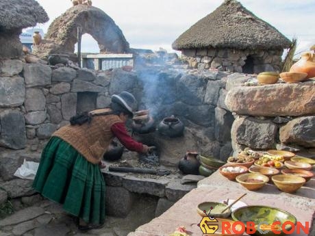 Một phụ nữ Quechua đang nấu nướng trong khu bếp lộ thiên