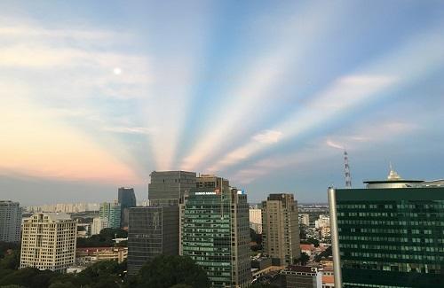 Tia nắng hình rẻ quạt bất ngờ xuất hiện trên bầu trời Sài Gòn