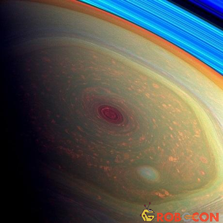 Bức ảnh được tô màu này cho thấy cực bắc của sao Thổ. Mắt bão ở trung tâm bức ảnh được tô màu đỏ, trong khi lốc xoáy xung quanh có màu xanh lá ngả vàng. Các đám mây có màu da cam, trong khi vòng xoay của sao Thổ được tô màu xanh ở góc trên bên phải.